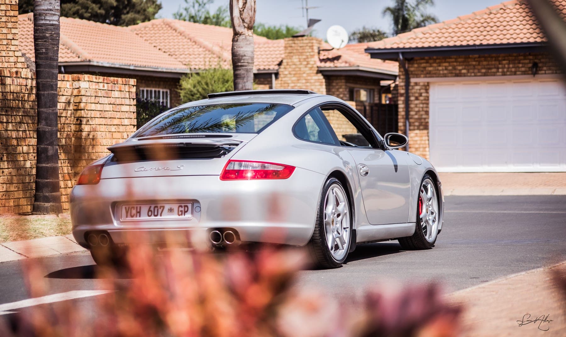 Silver Porsche 911 from behind in a driveway