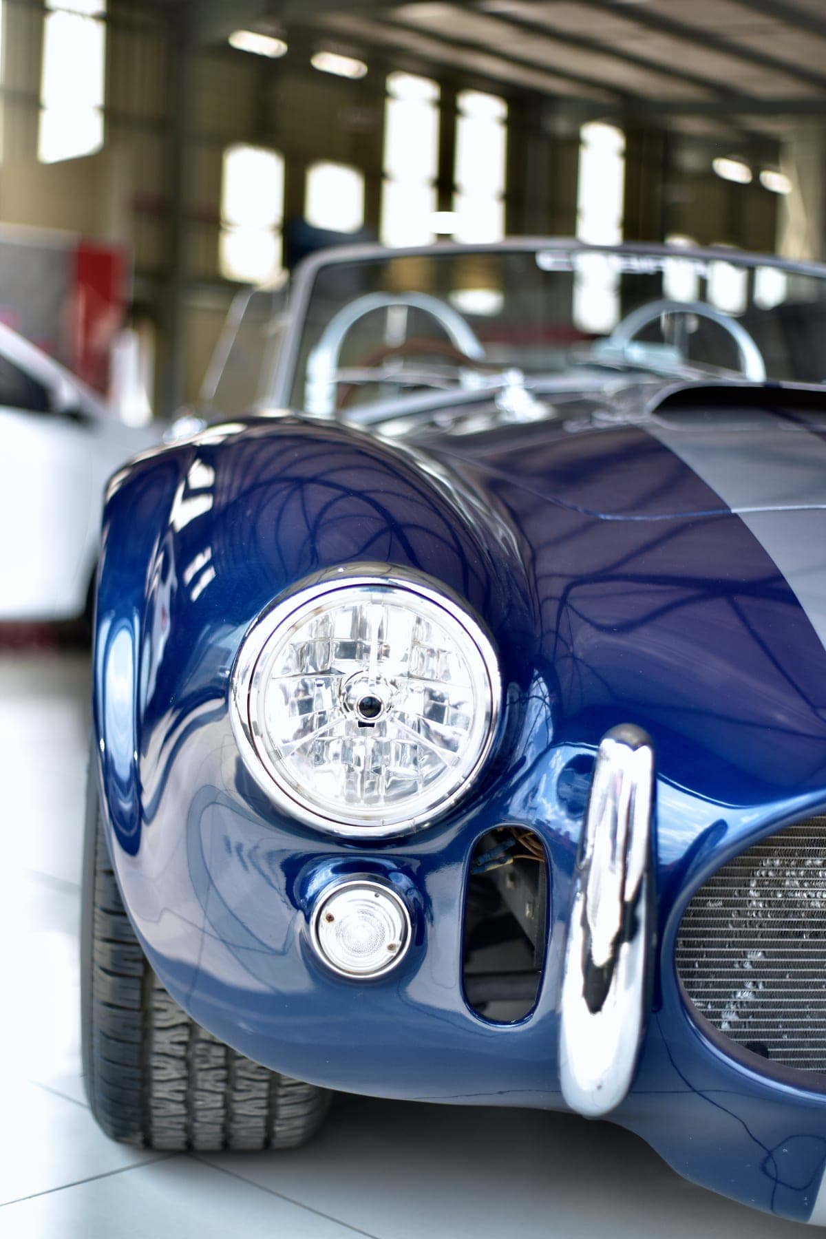 Blue AC Cobra headlight and side pipe in the workshop
