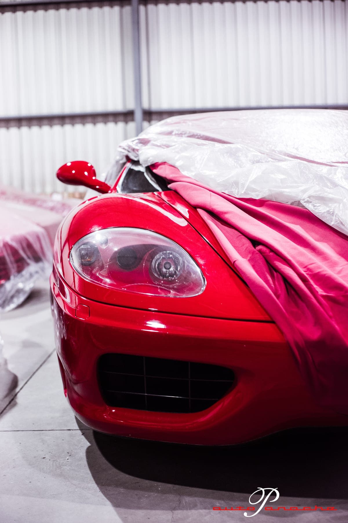 Red Ferrari 360 nose under a dust cover