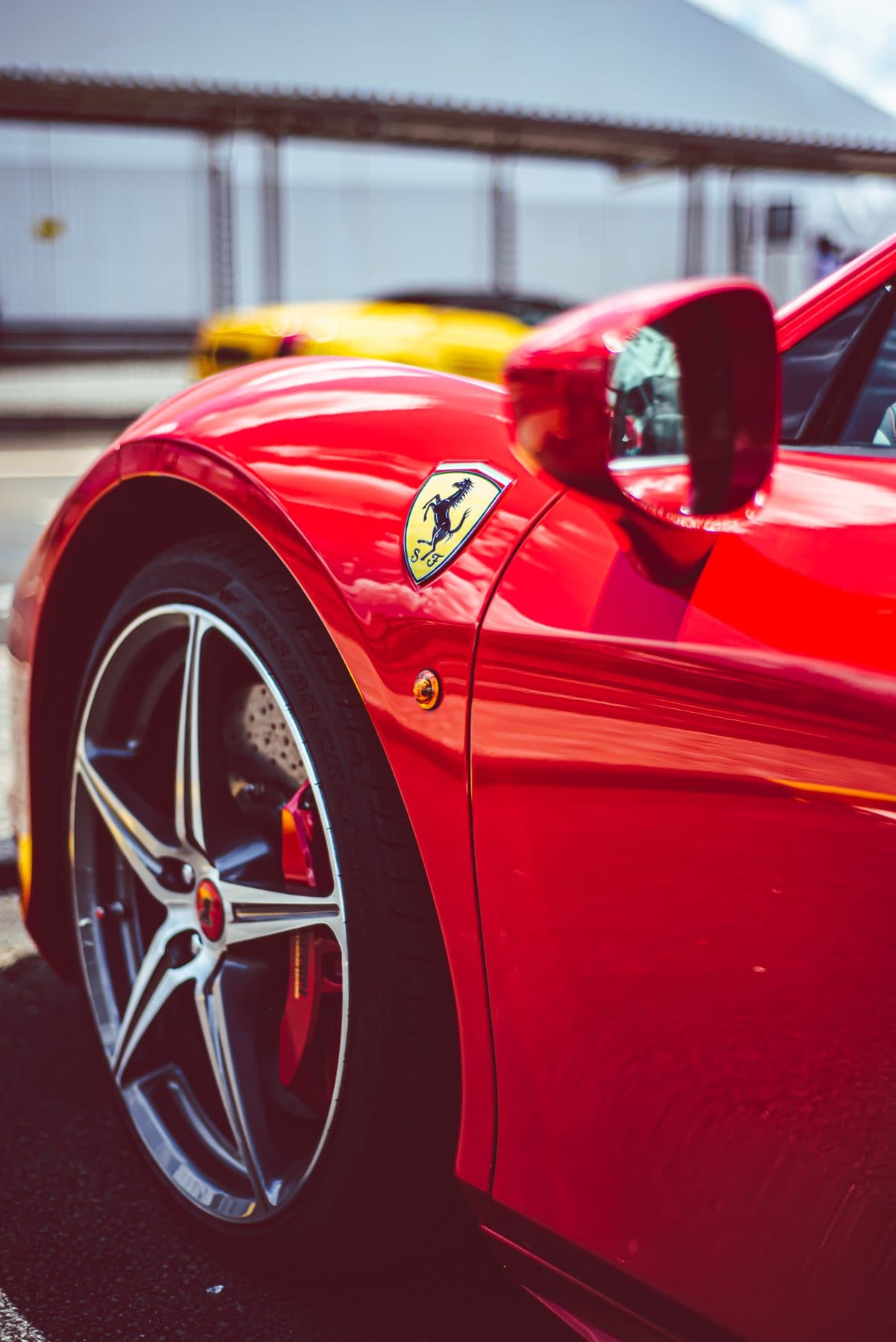 Red Ferrari front wheel and badge in sunlight