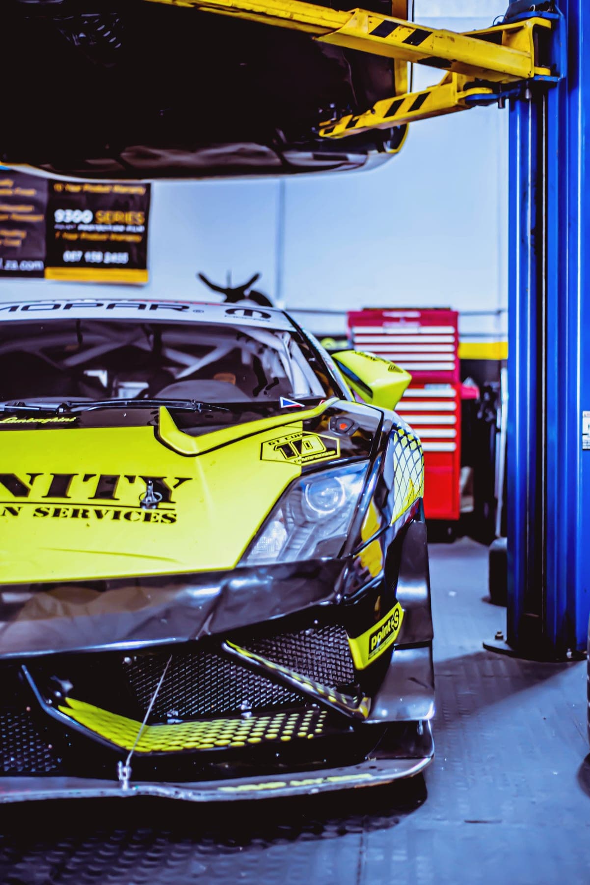 Lamborghini Huracán in yellow livery on a workshop lift