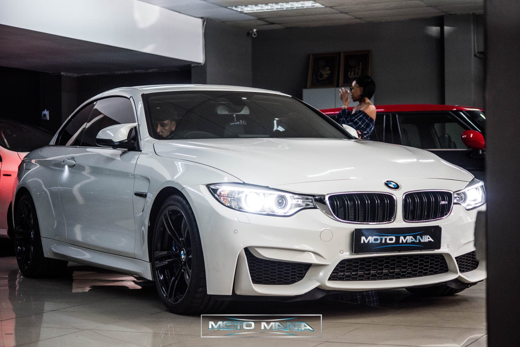White BMW M4 front quarter under showroom lights
