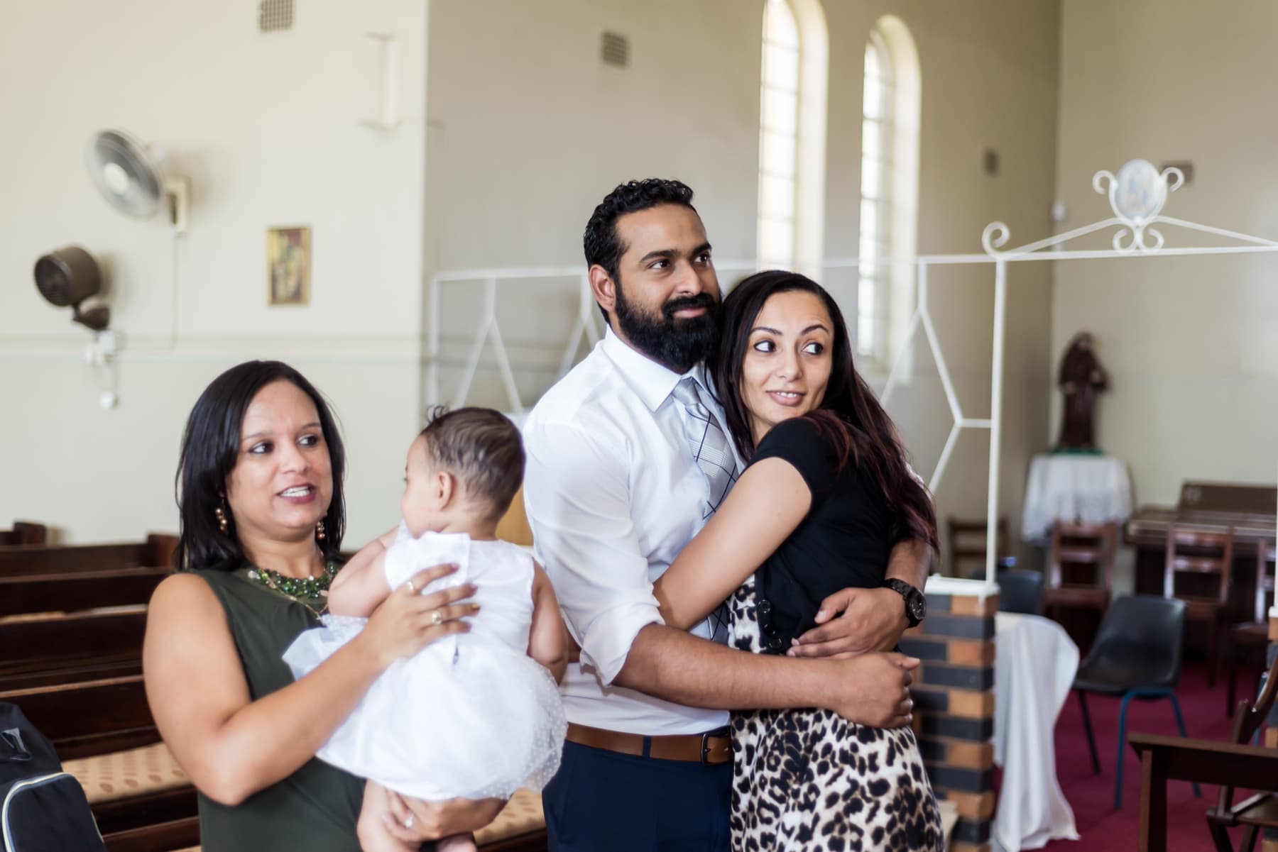 Family embrace in the chapel at a christening
