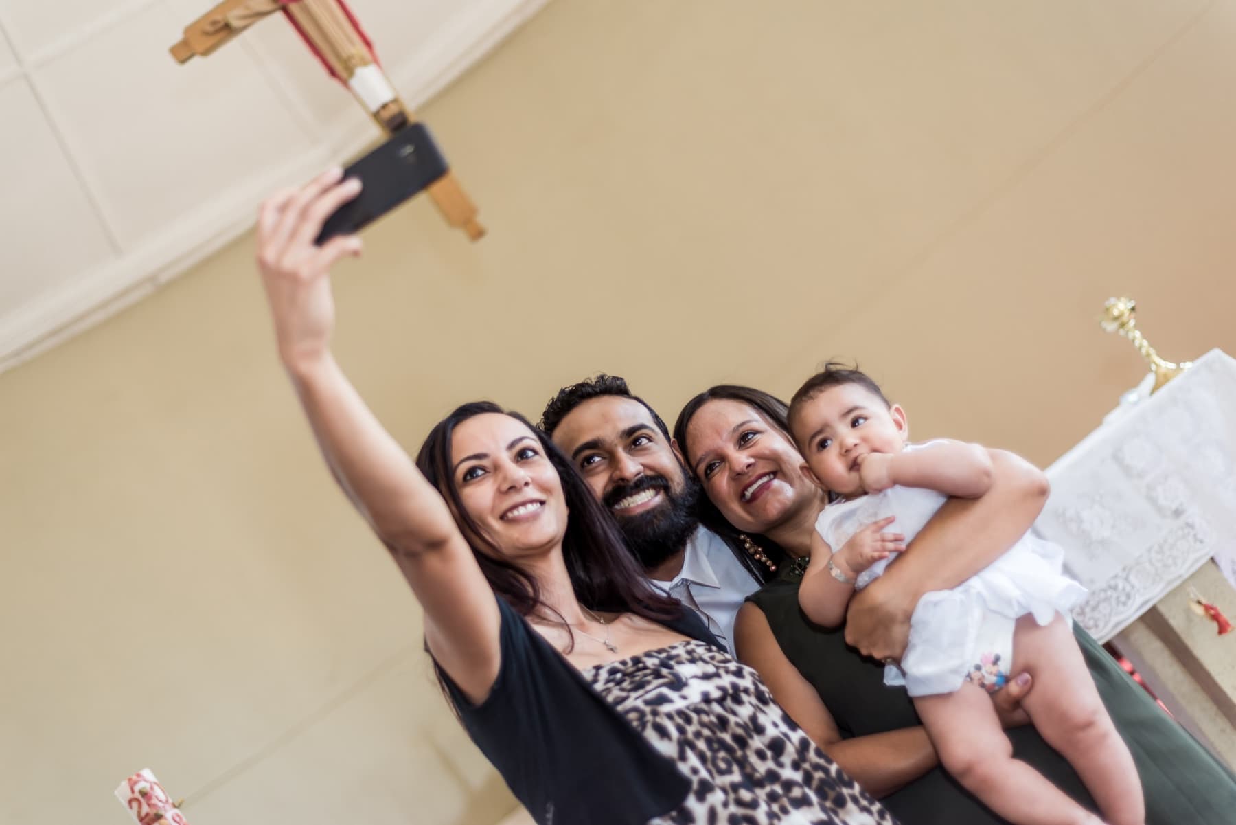 Family selfie by the altar candles at a christening