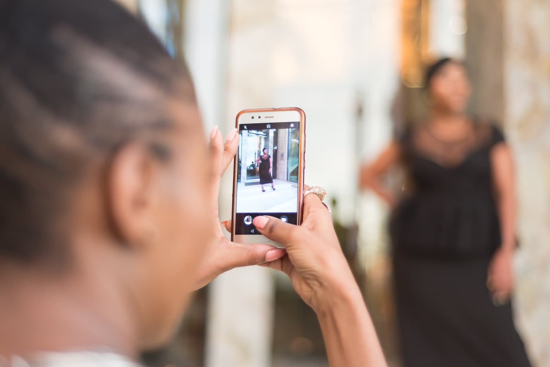 A phone screen framing a guest in black