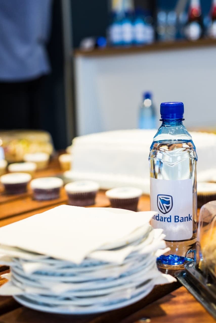 Standard Bank water and branded napkins on the launch table, close