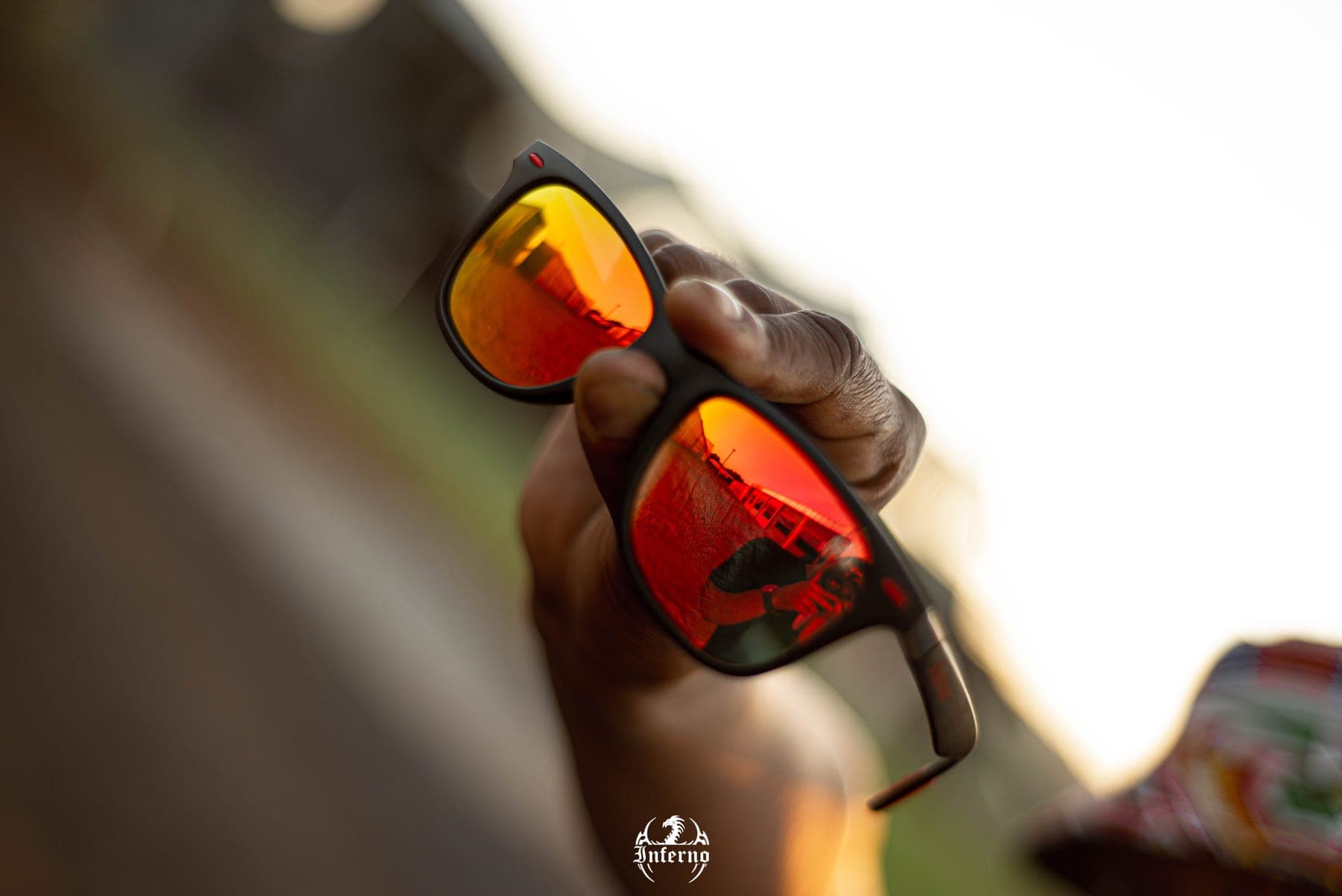 Orange mirrored sunglasses held up to the light
