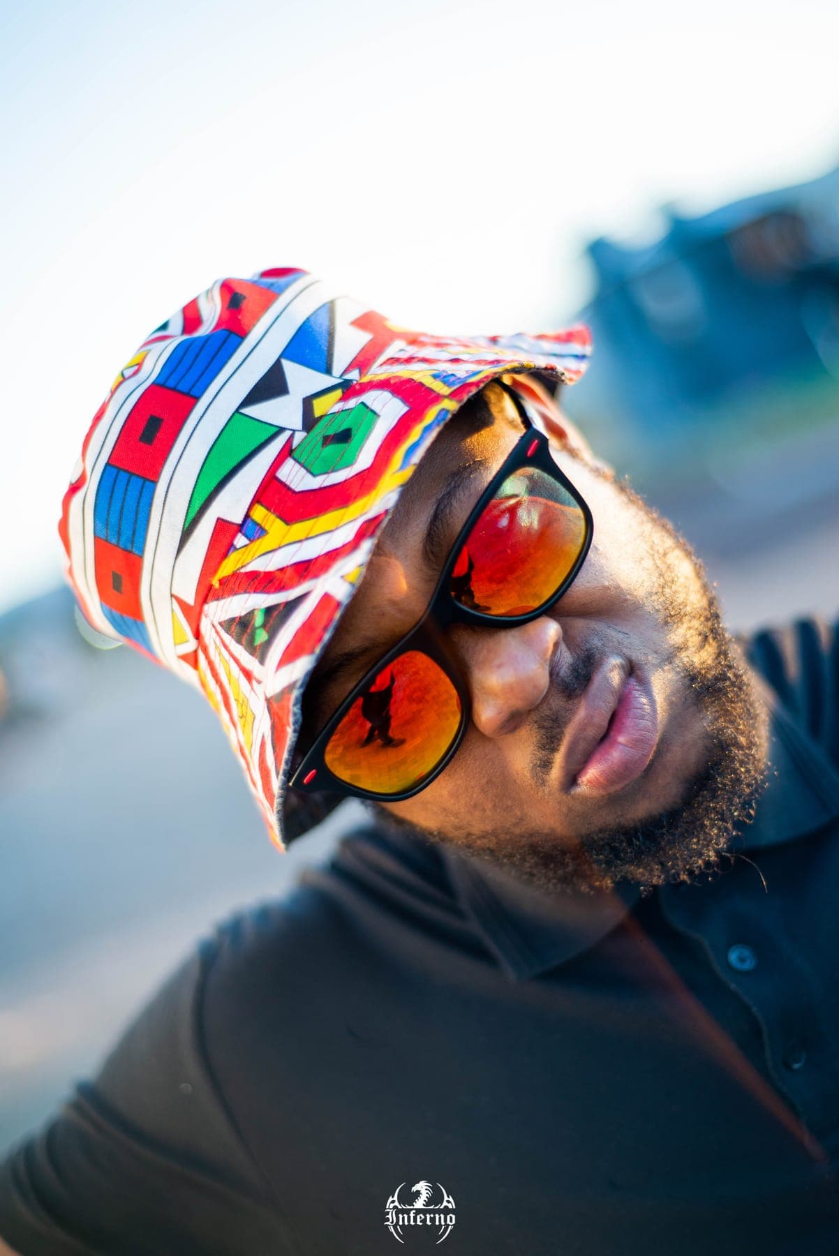 Man in a printed bucket hat and orange mirrored sunglasses