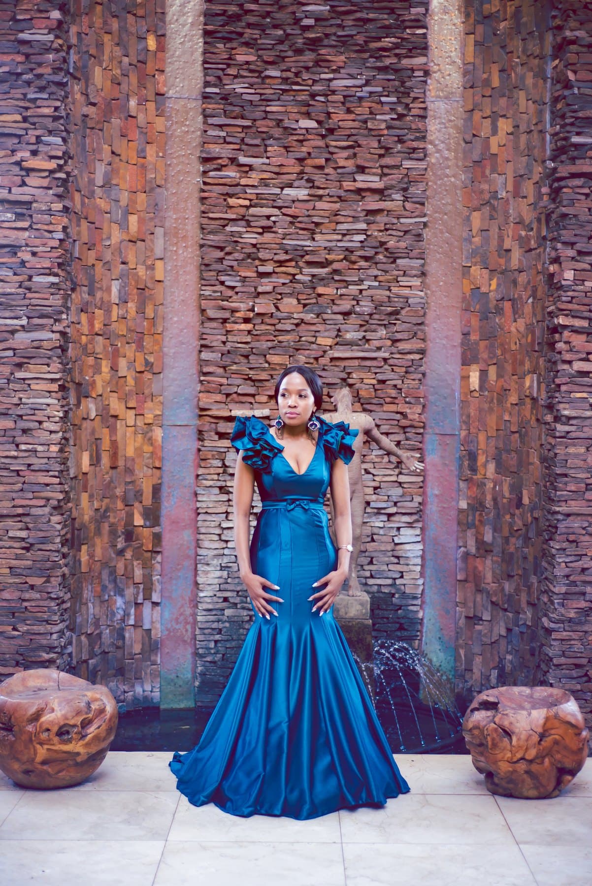 Teal mermaid gown before a slate stone wall