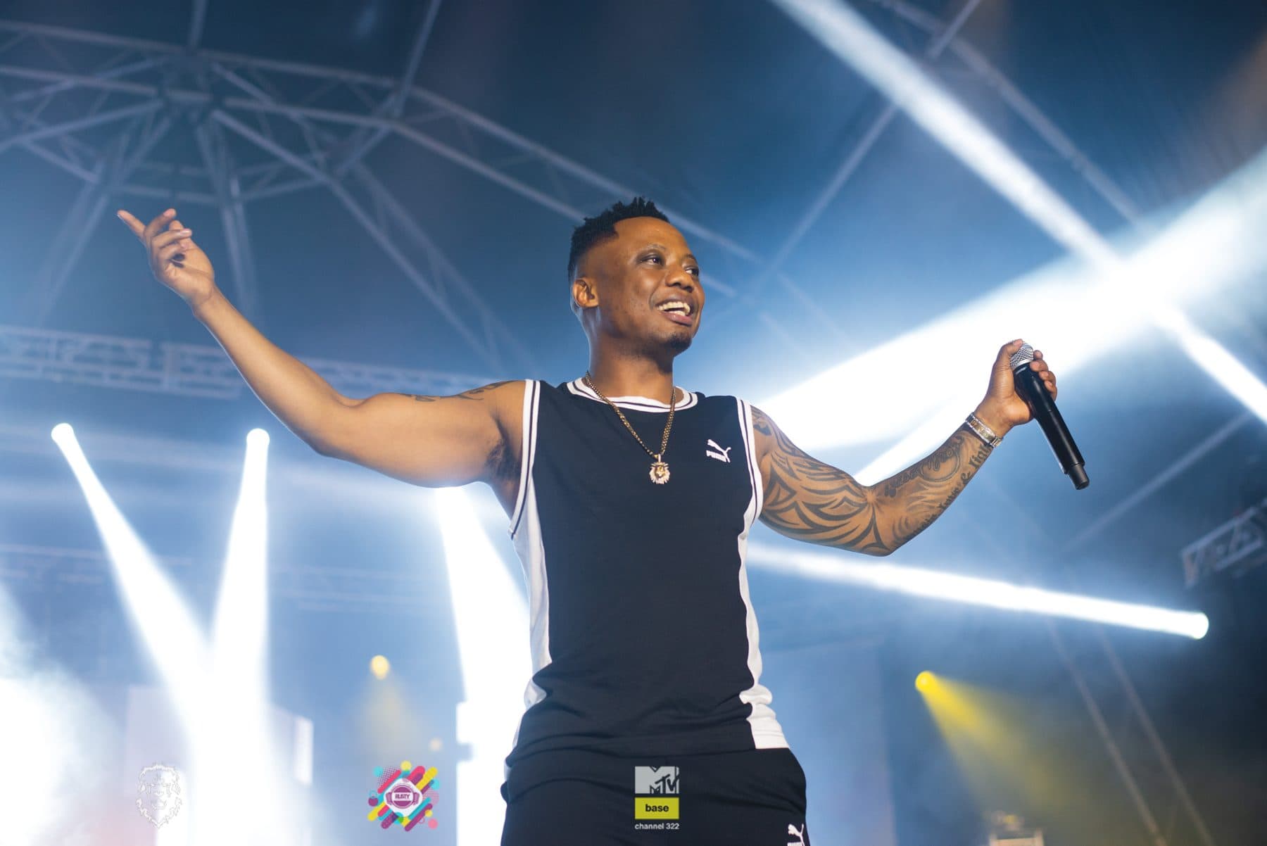 Performer with arms out in front of white stage lights