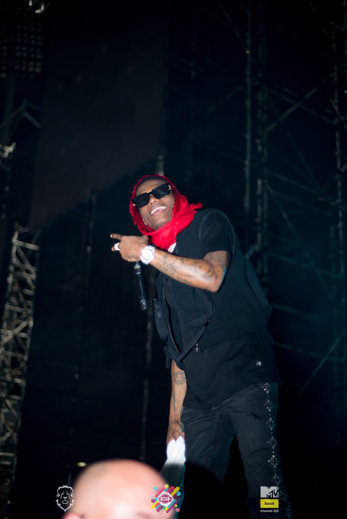 Rapper in a red bandana pointing, lit from below
