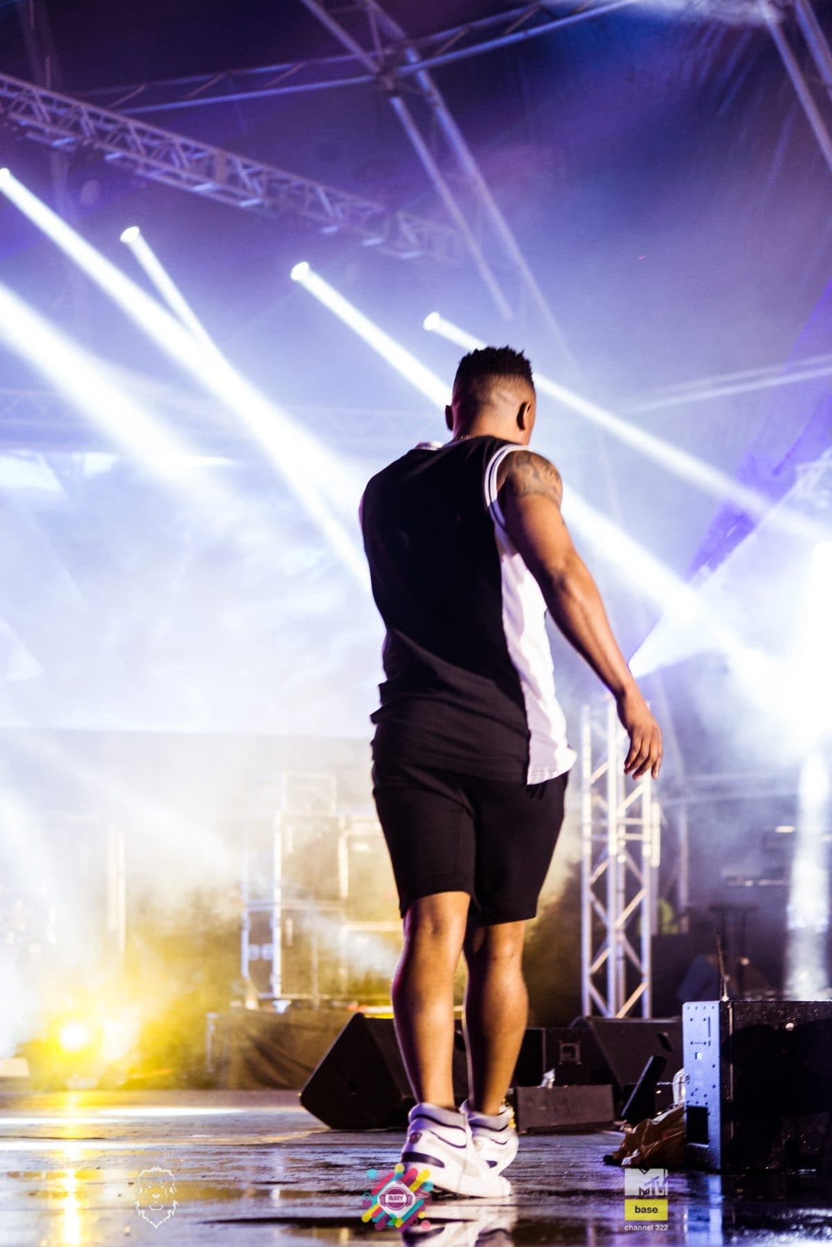 Singer on stage between blue and orange beams