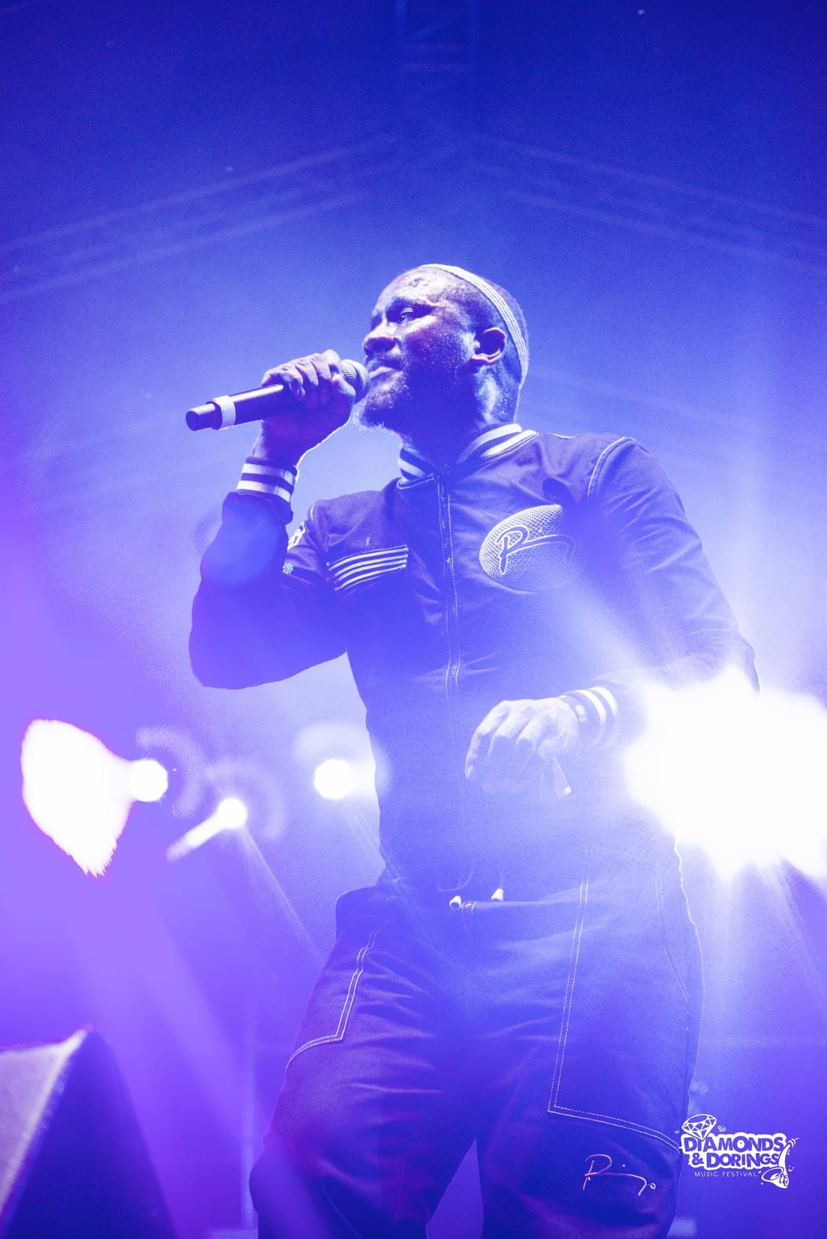 Vocalist in a blue stage wash, mic raised