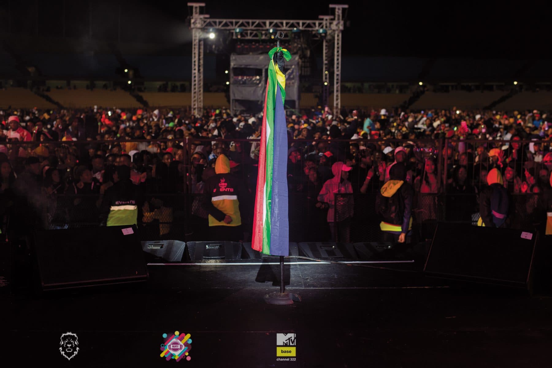 Festival crowd in front of a lit stage at night