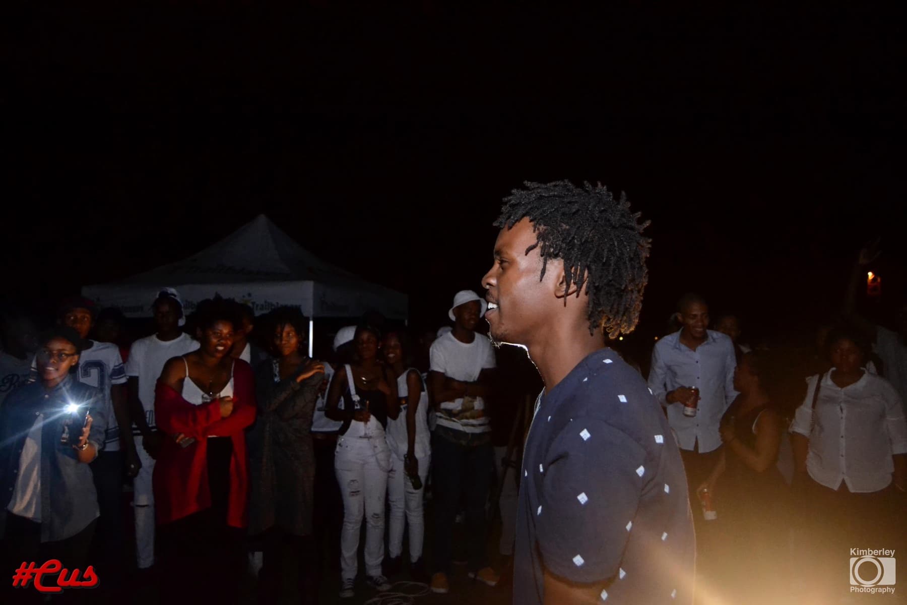Dreads in profile over the crowd at the #Cus night