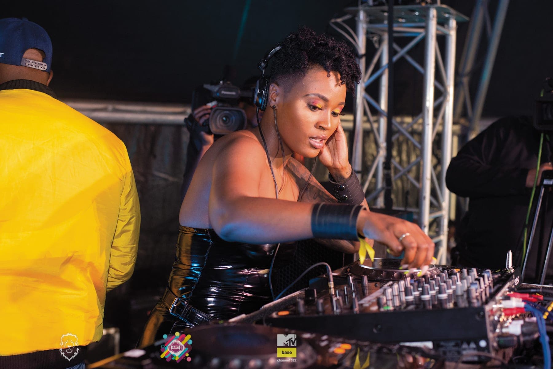DJ at the mixer beside a man in yellow