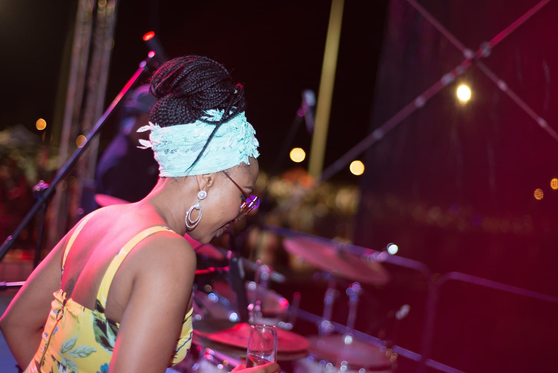 Woman in a lace headwrap at the side of the DJ booth