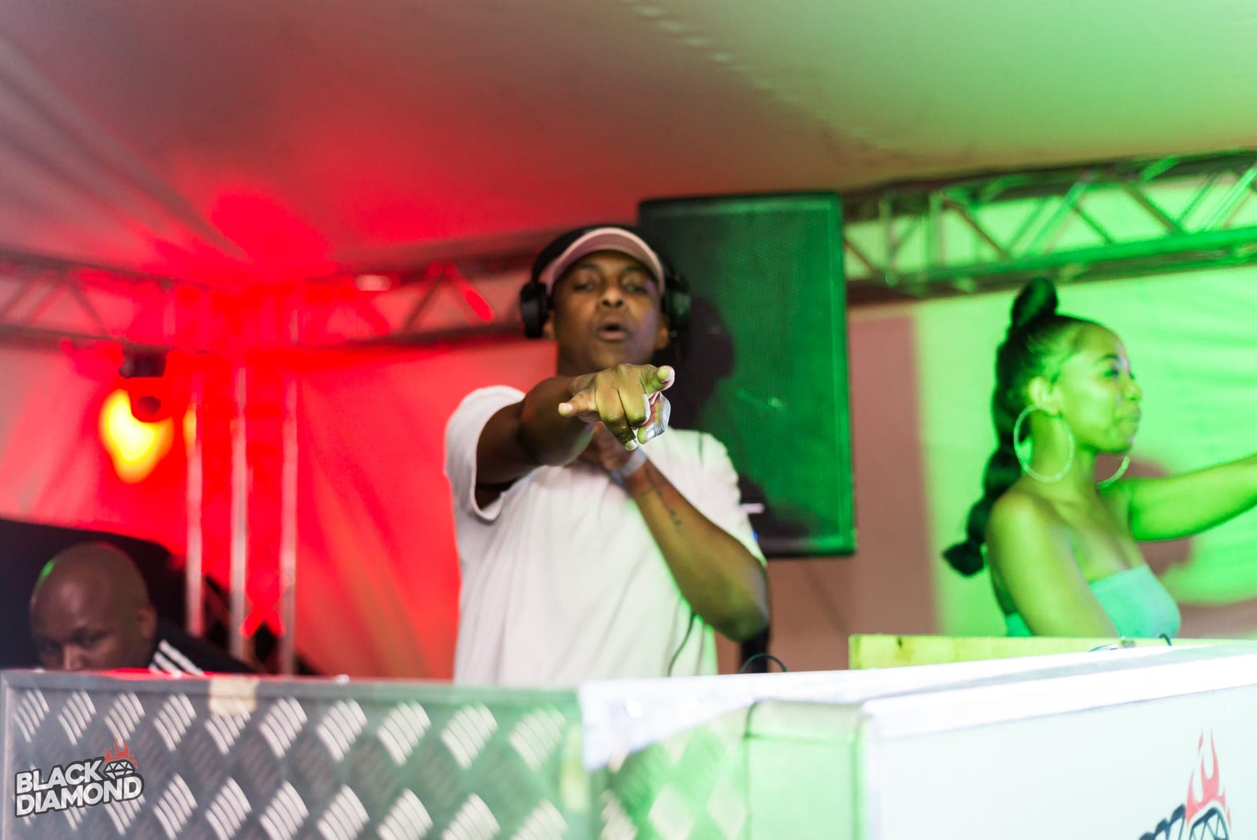 Two at the decks in a red wash, one pointing at the lens