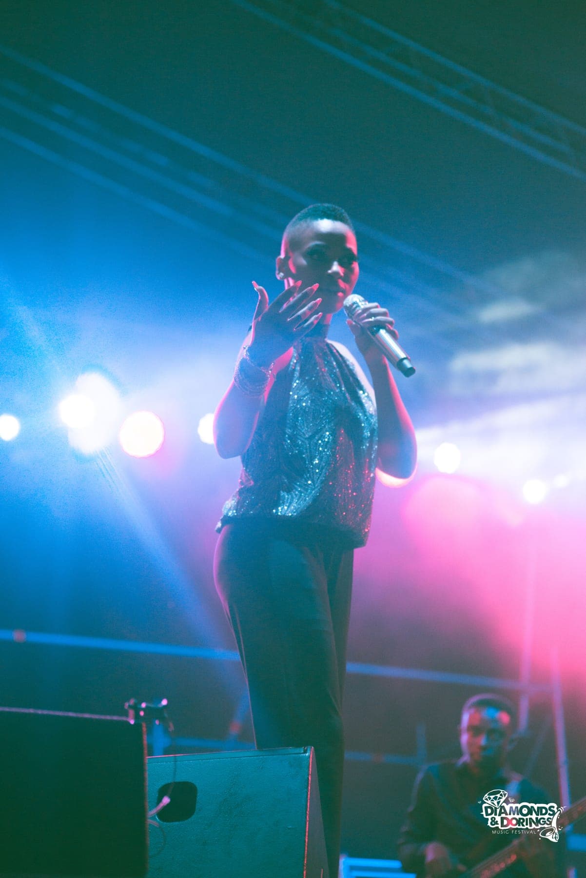 Singer mid-song under blue and pink lights