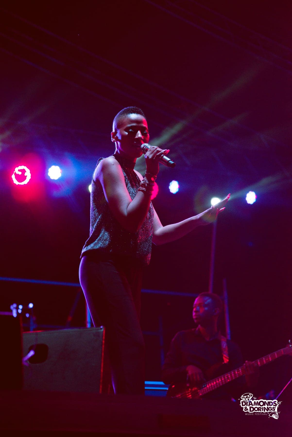 Singer on stage between red lights