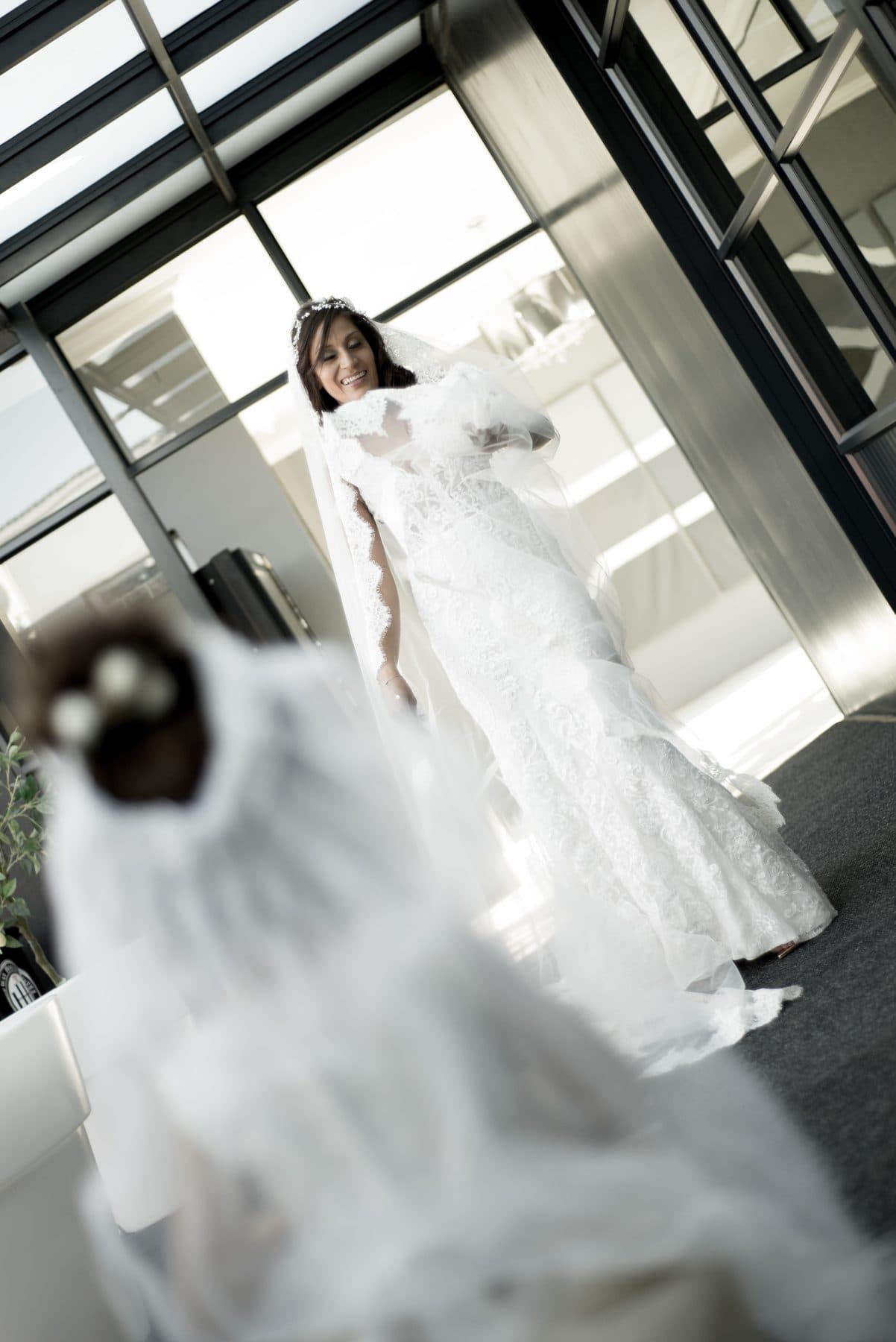 Bride in a veil walking through a bright hall