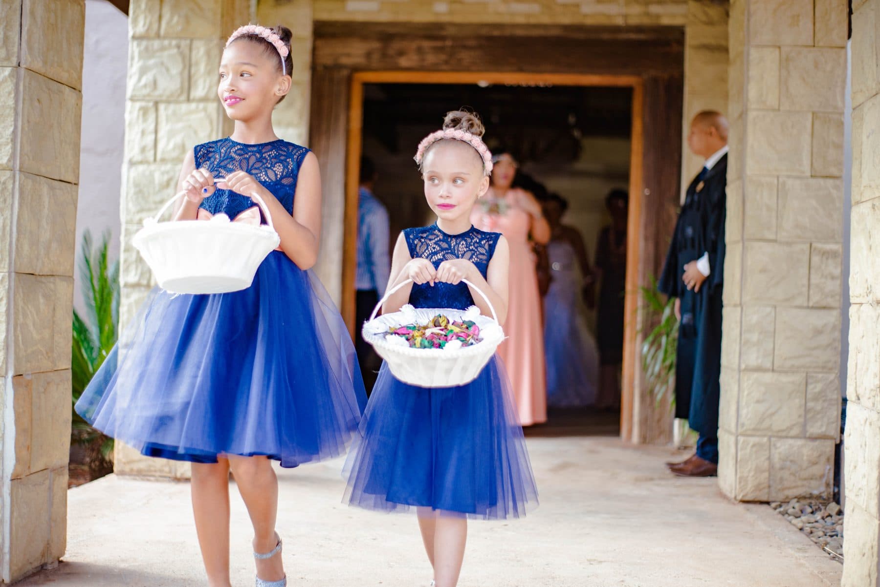 Flower girls in blue dresses on stone steps