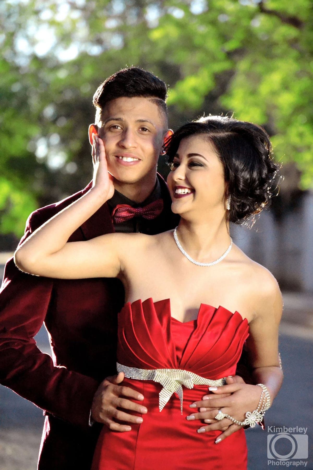 Couple in burgundy and red laughing cheek to cheek