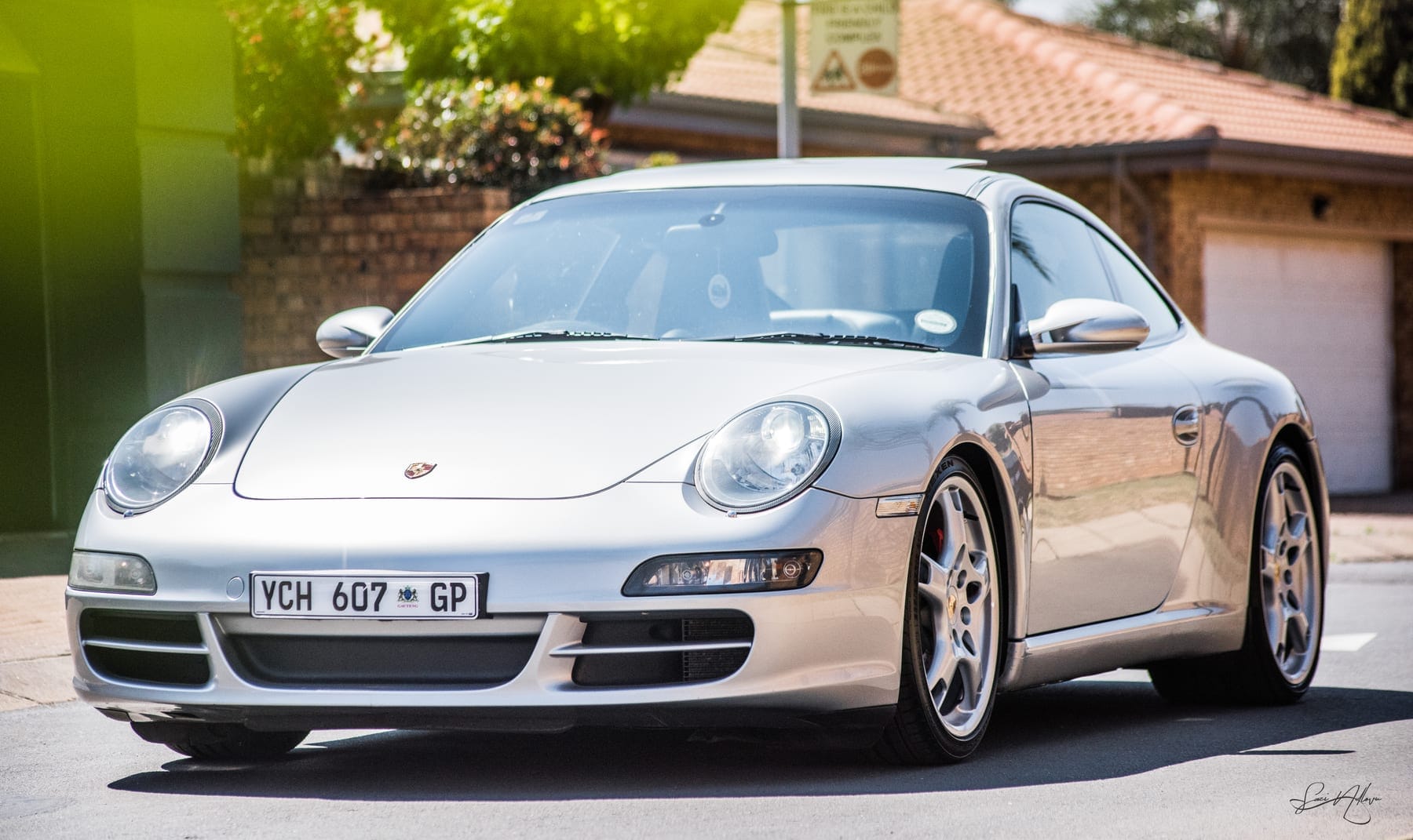 Silver Porsche 911 front quarter in the sun