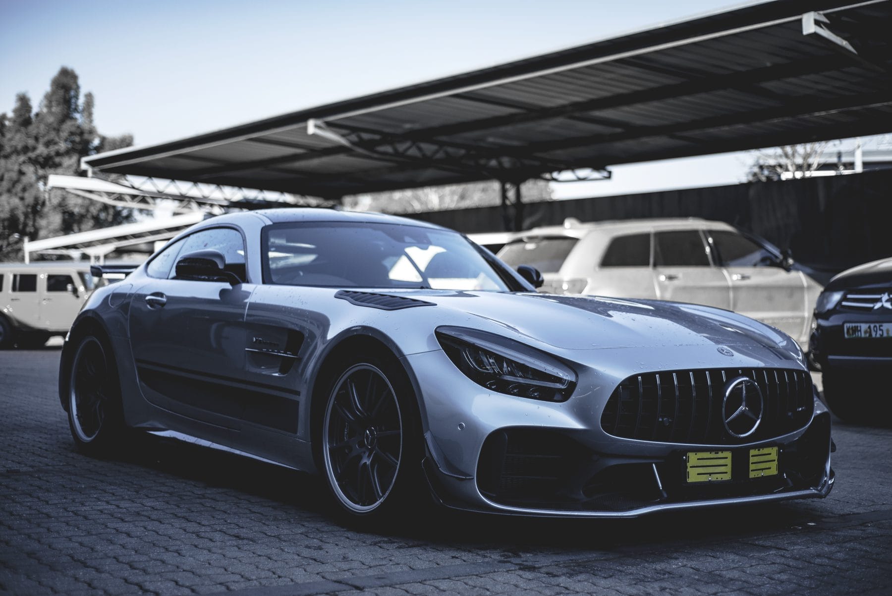 Grey Mercedes-AMG GT nose-on under a carport