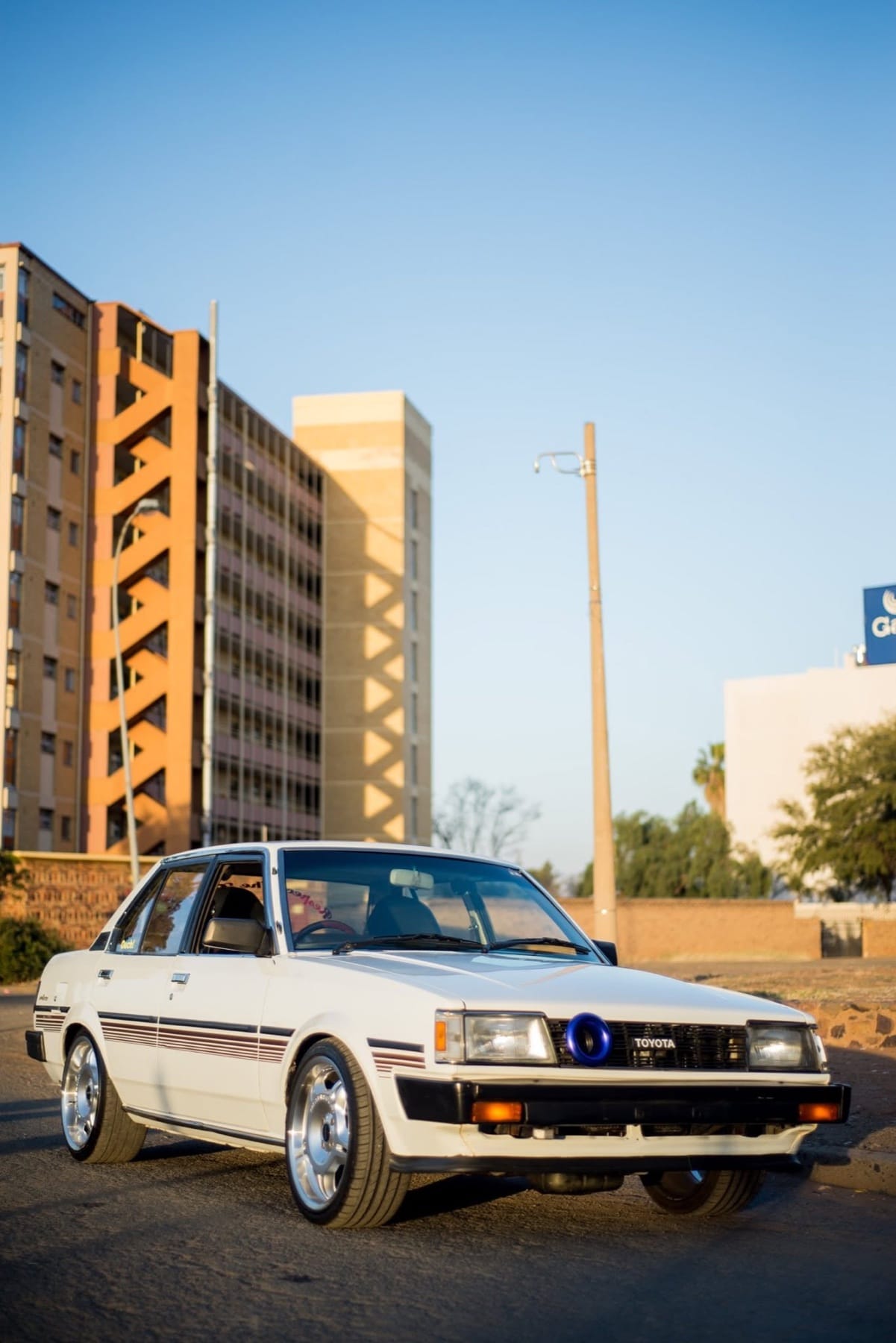 White Toyota Corolla on a city street at golden hour