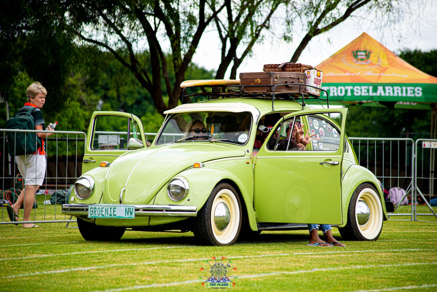 Pale green Volkswagen Beetle with luggage on the roof rack