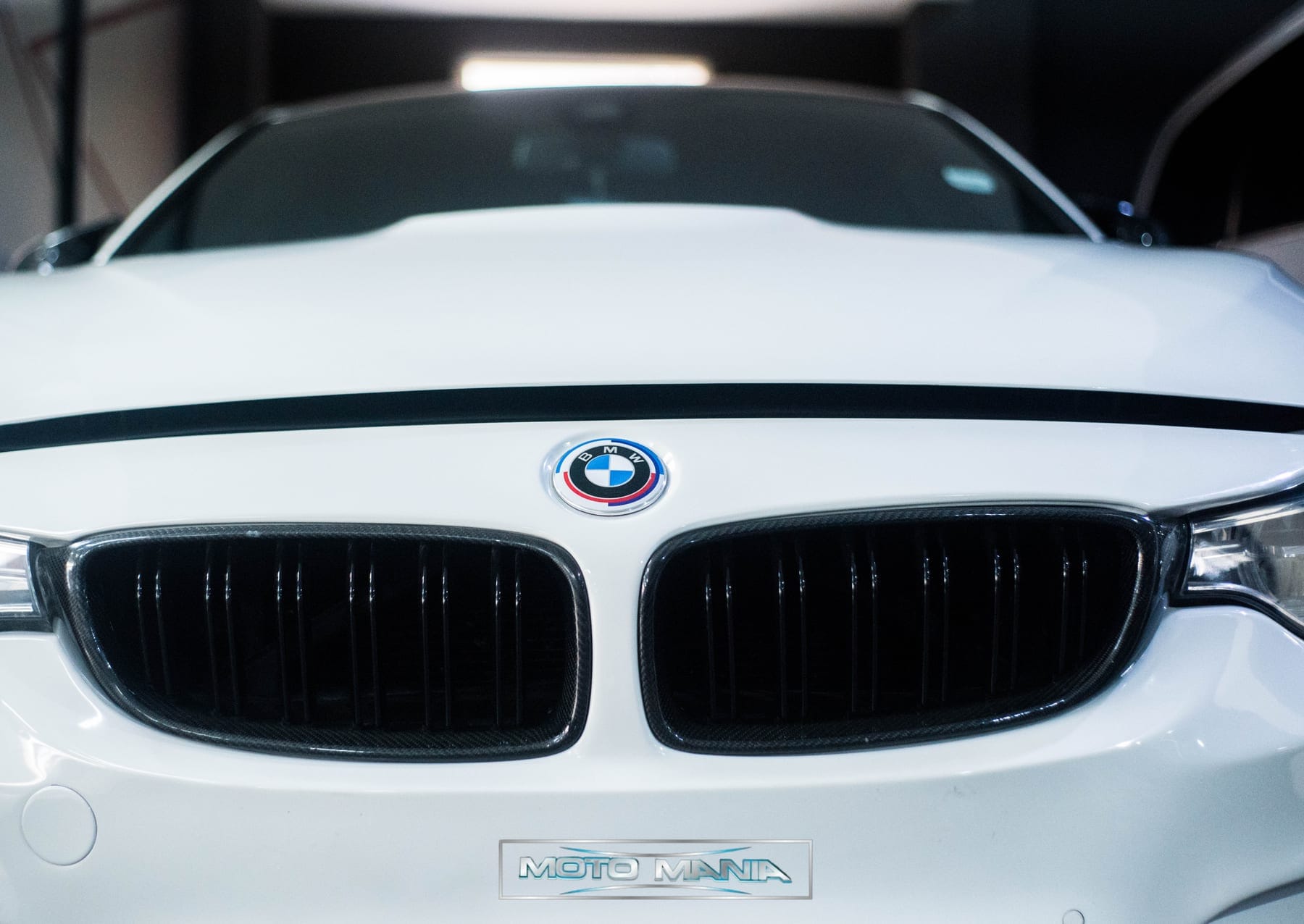 White BMW M4 nose and badge in the showroom