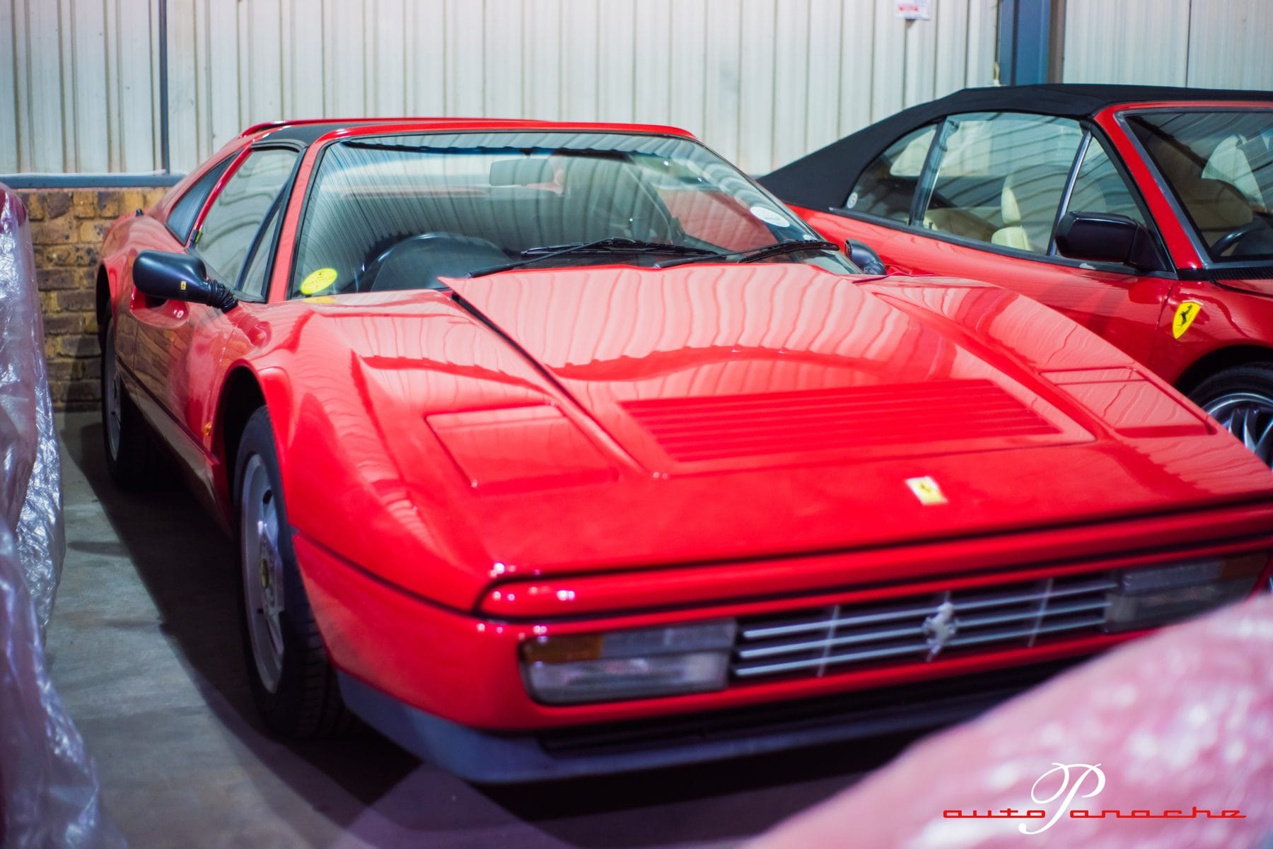 Red Ferrari Testarossa under a shed roof