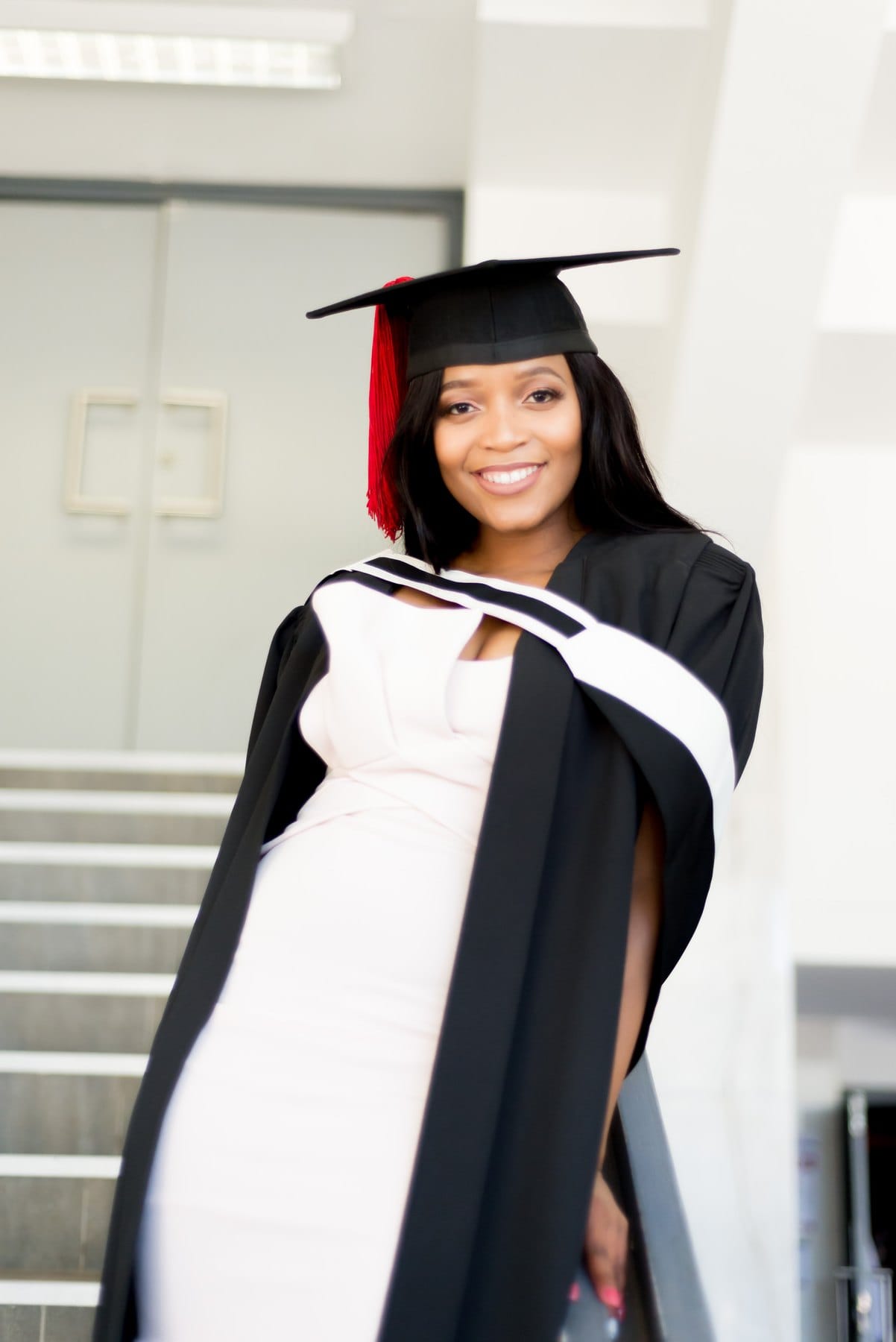 Graduate in cap and gown with a red tassel