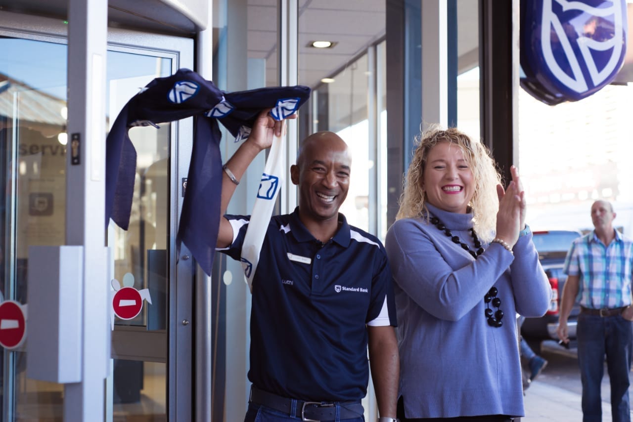 Standard Bank staff cheering as the ribbon comes down at a branch opening