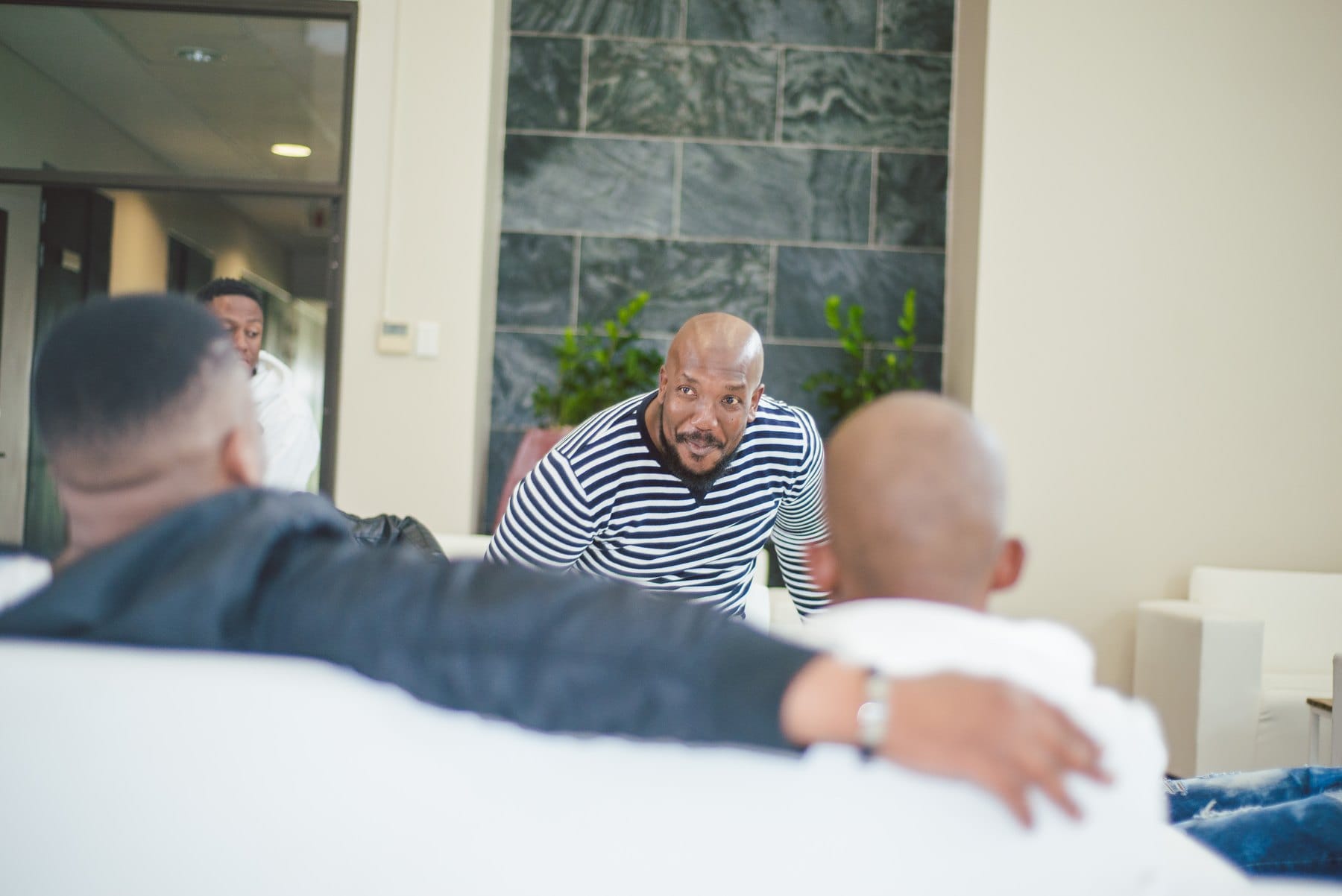 Man in a striped shirt leaning in over a lounge