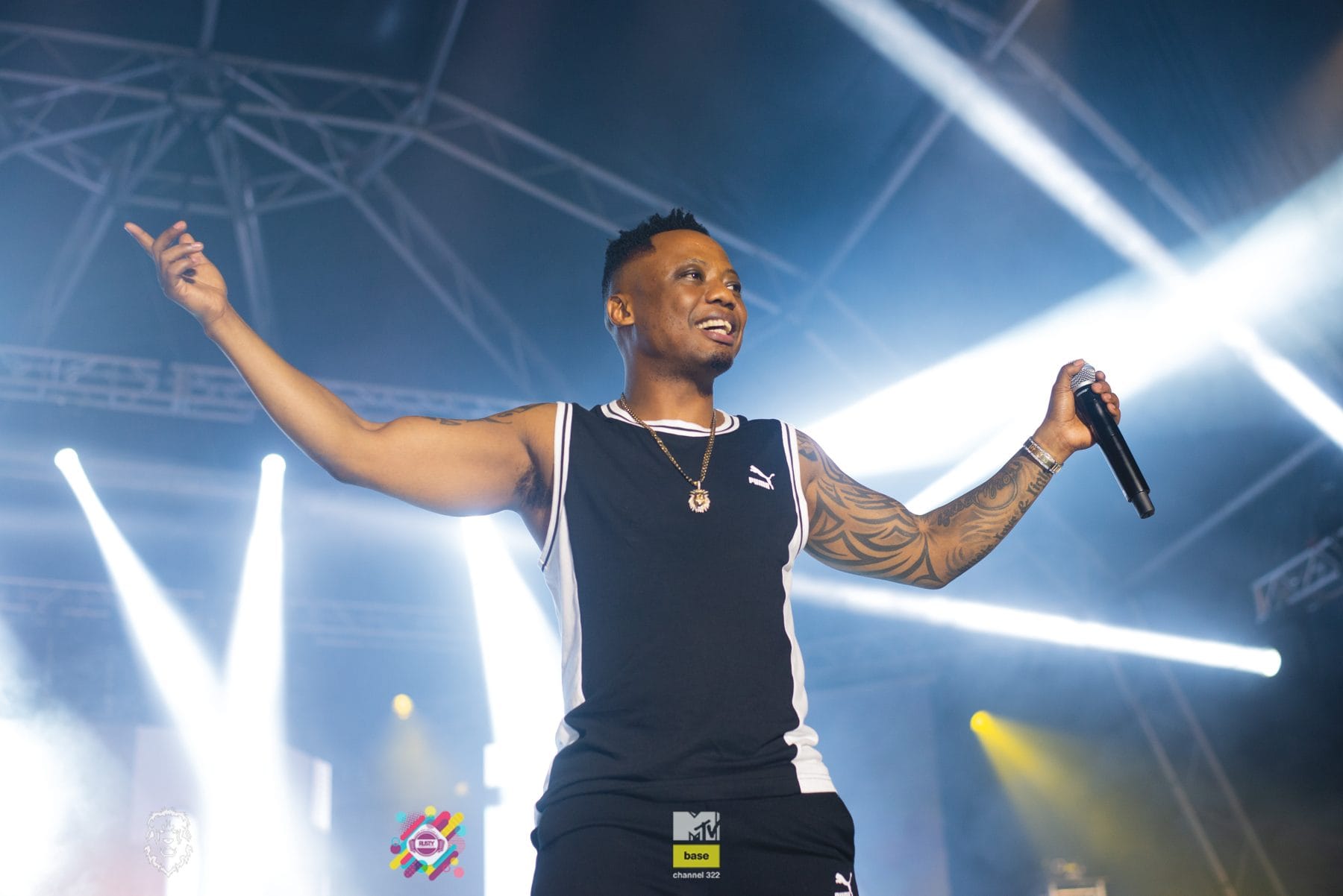 Performer with arms out in front of white stage lights