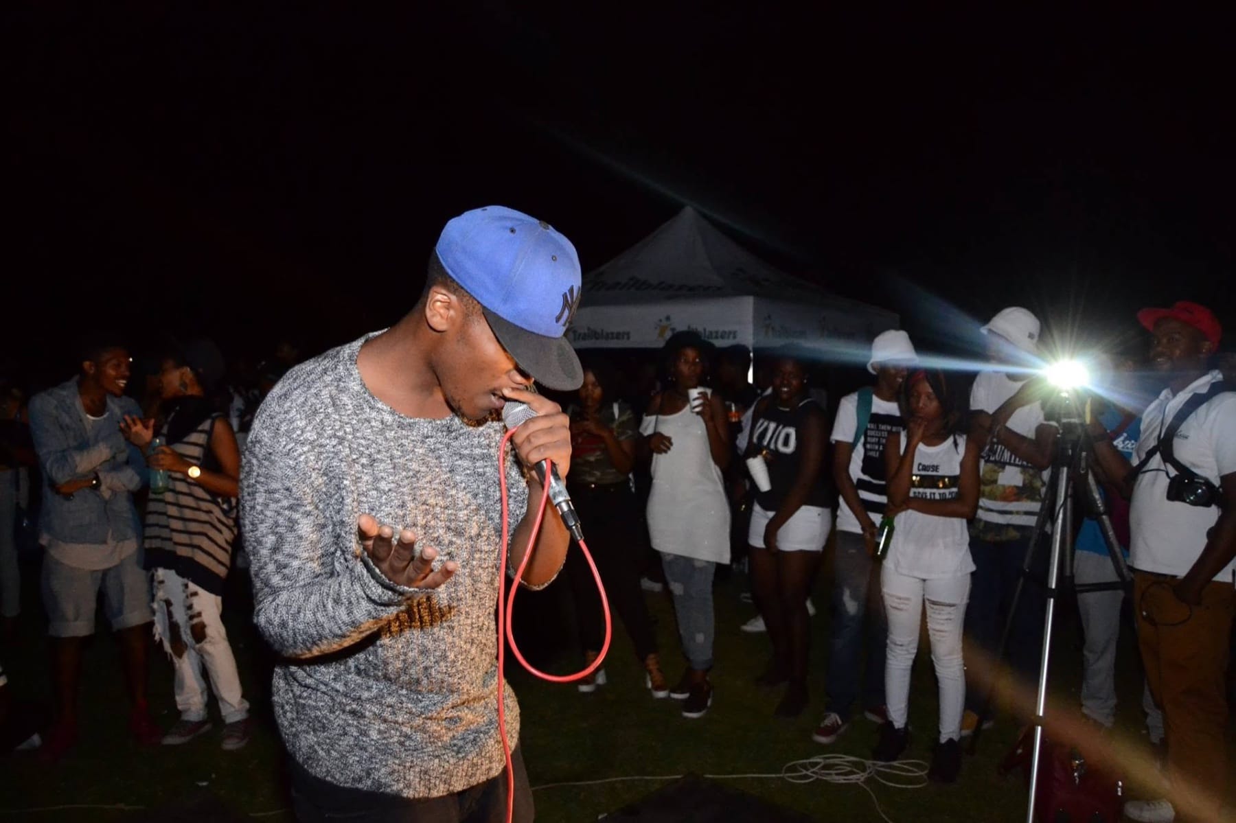 Rapper in a blue cap on the mic at a night show