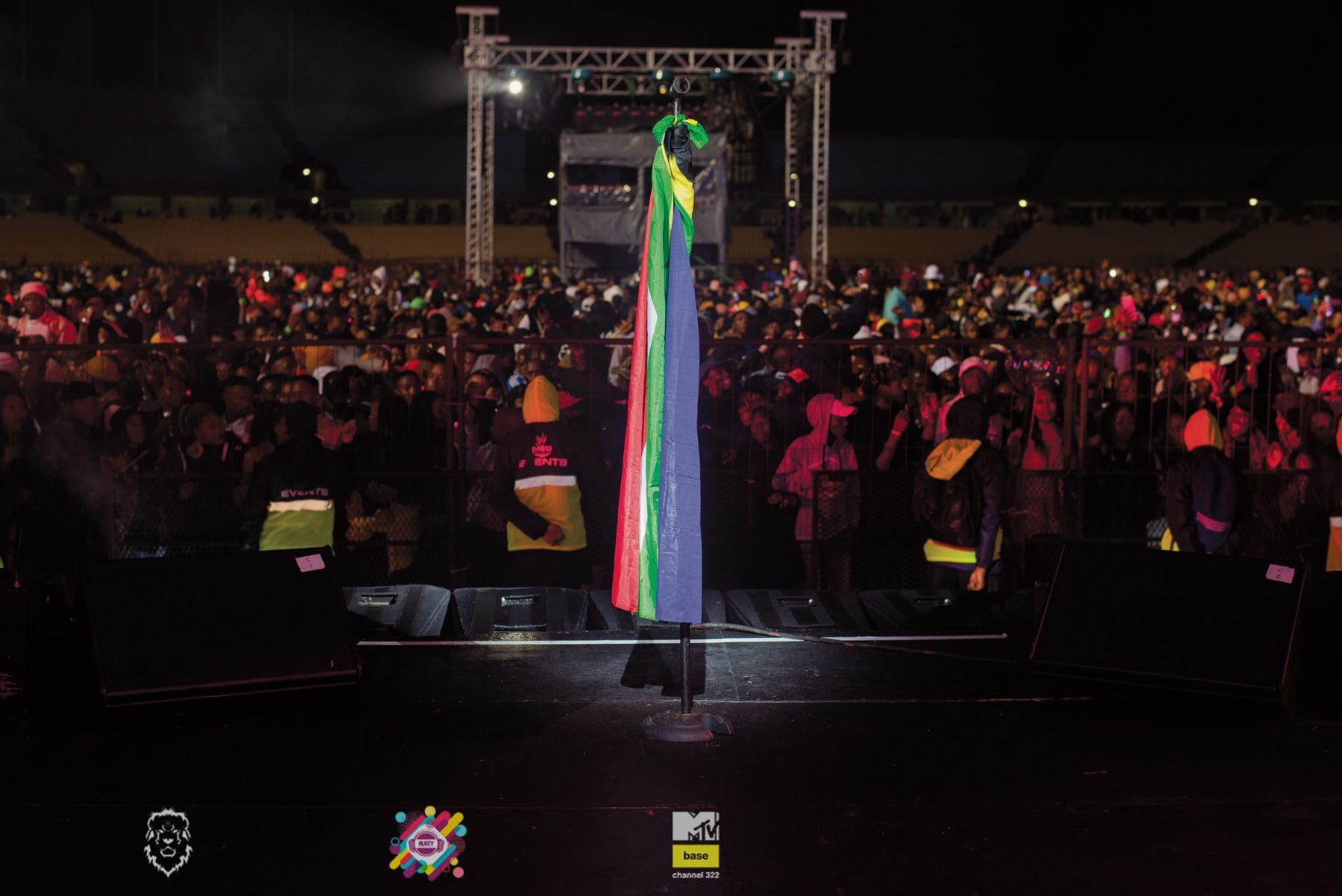 Festival crowd in front of a lit stage at night