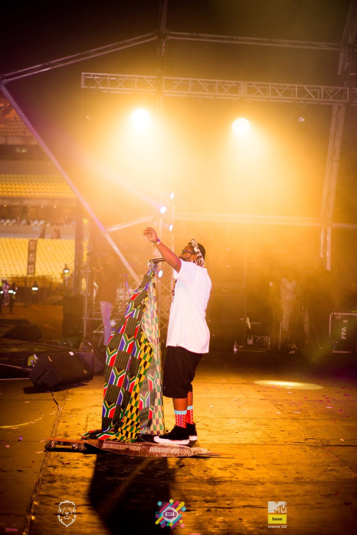 Artist walking the stage under an orange spotlight