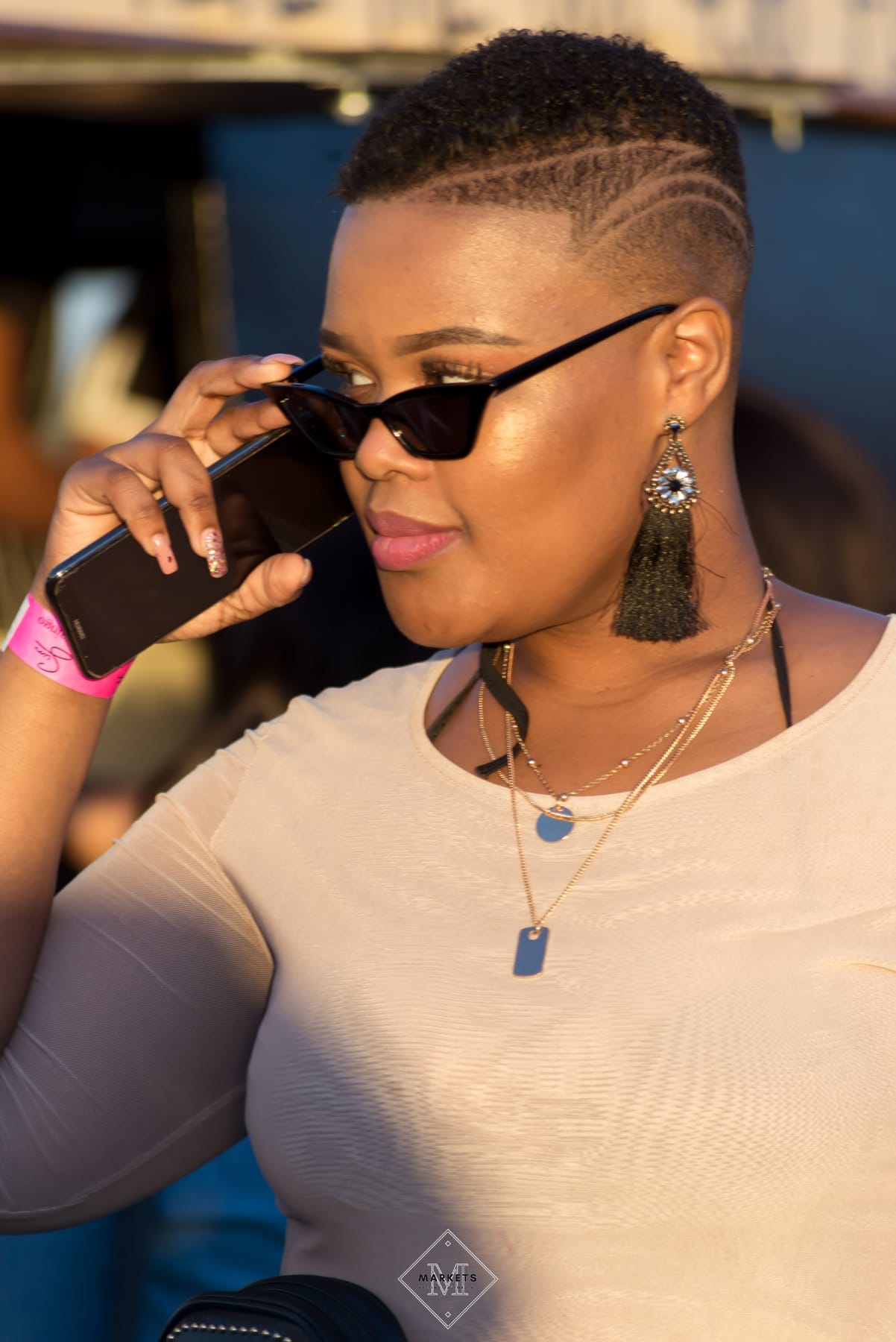 Woman in sunglasses on a phone call at a festival
