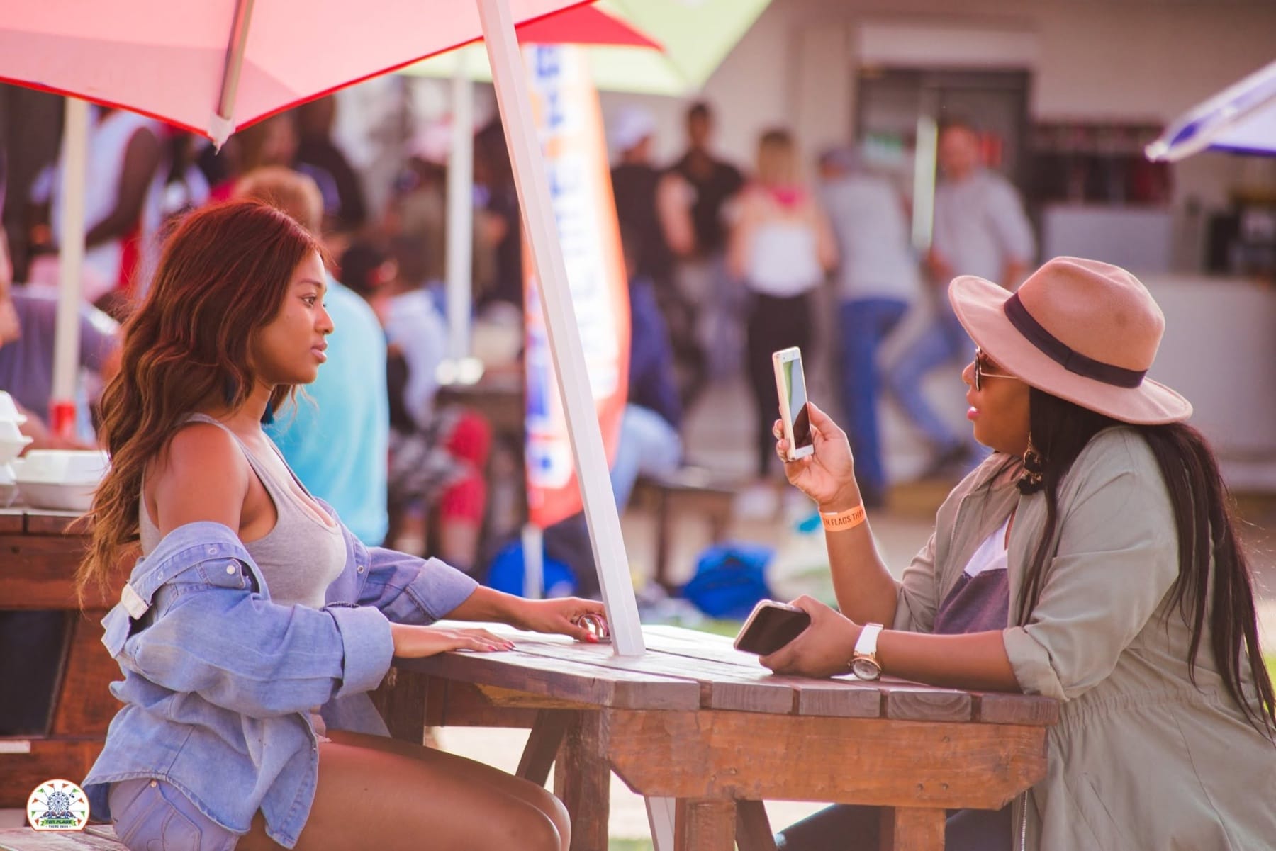 Leaning on a picnic table under red umbrellas