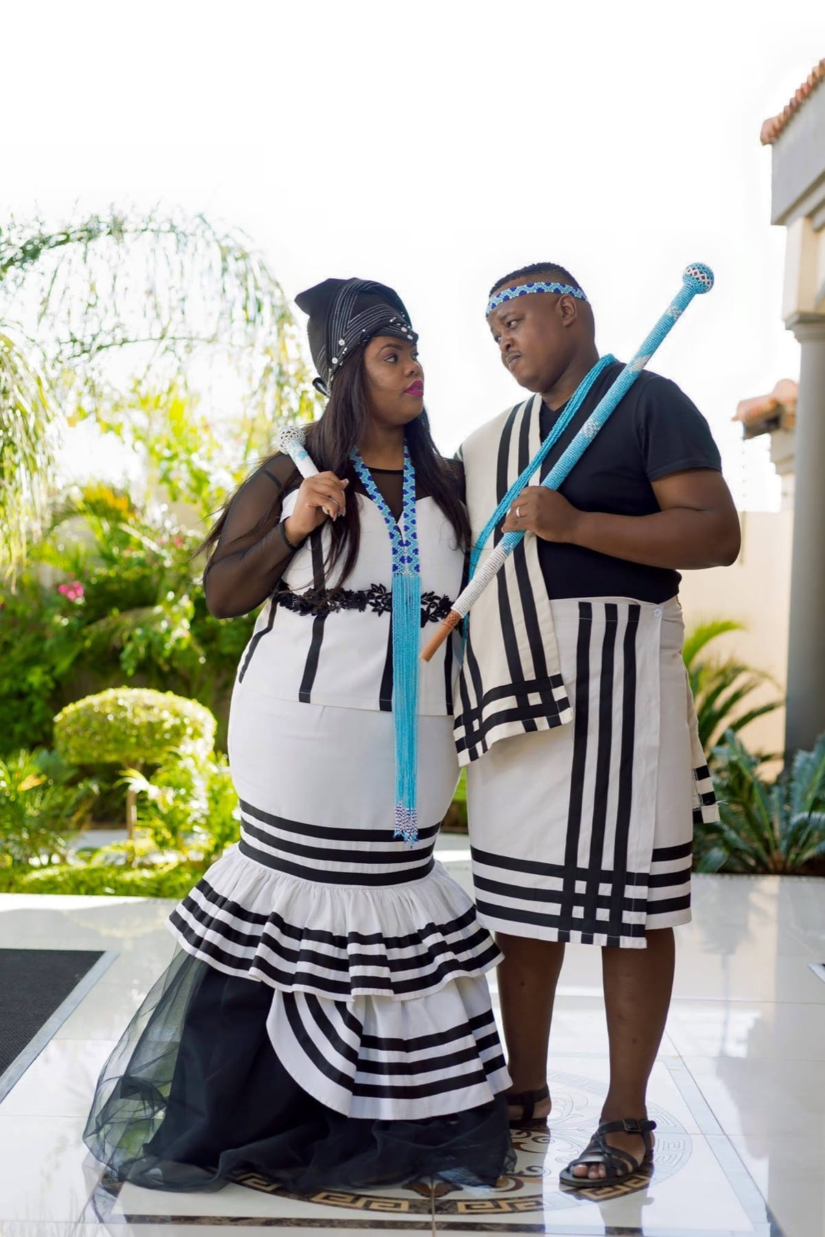 Couple in black and white Xhosa attire, eyes meeting